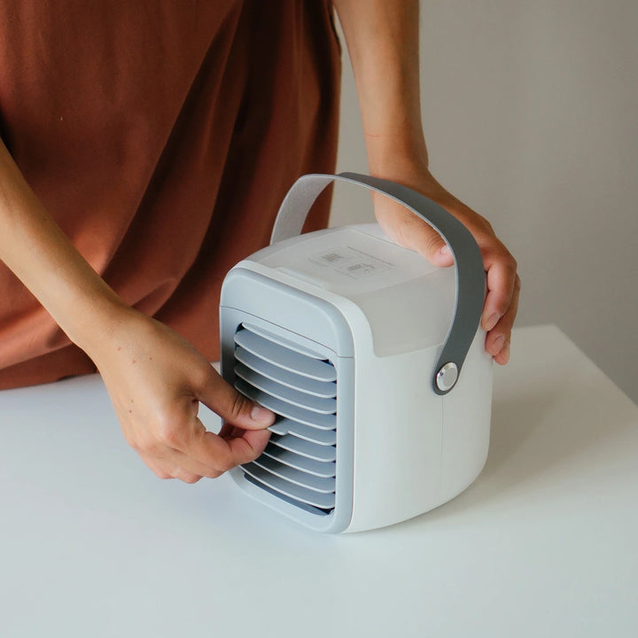 Person holding the compact white and grey air cooler