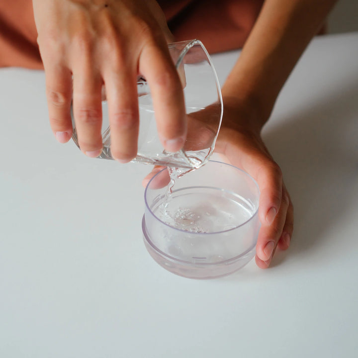 Individual filling a mini fan humidifier with water