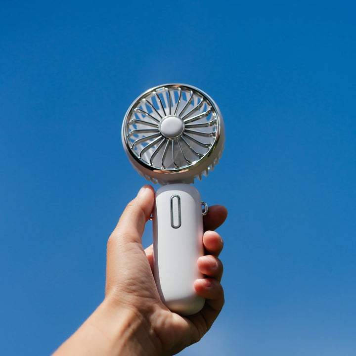 Individual showcasing a portable rechargeable handheld fan