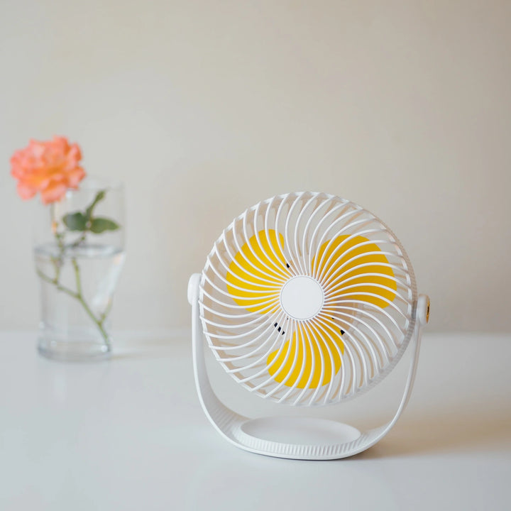 7 Inch Rechargeable Desk Fan in white on a table beside a different flower vase