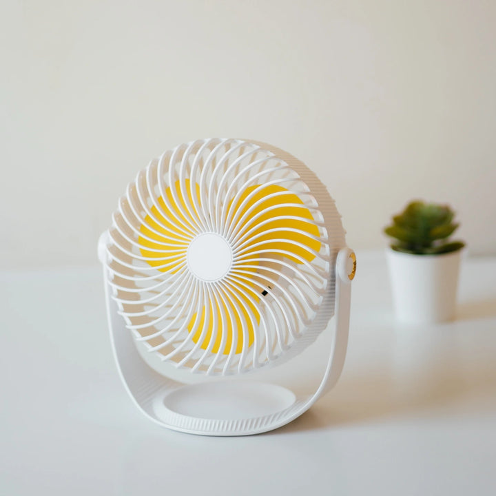 7 Inch Rechargeable Desk Fan in white and yellow placed on a table